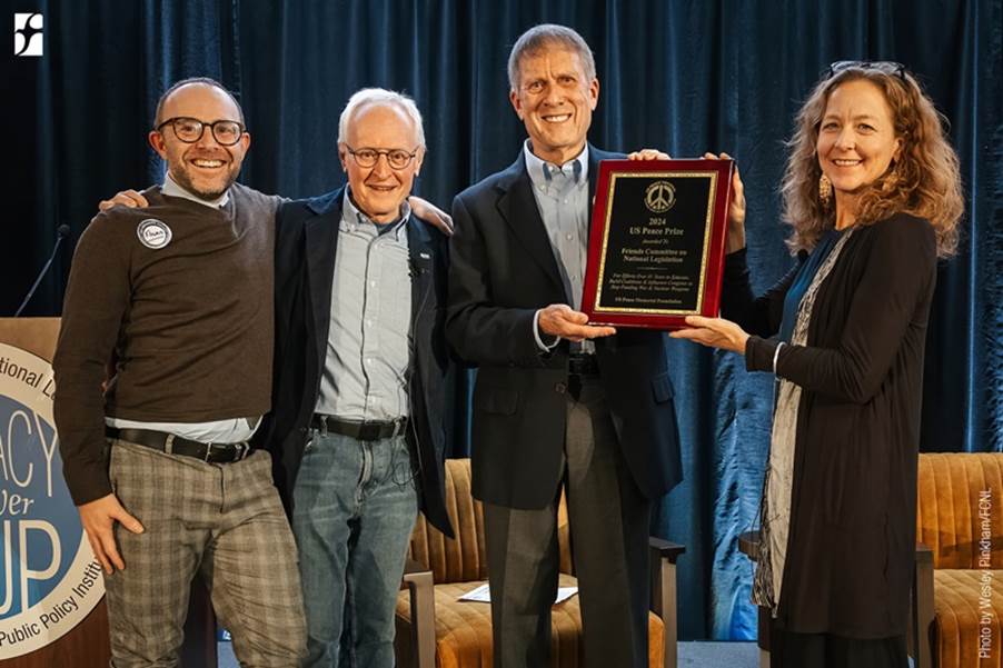 A group of people holding a plaque

Description automatically generated