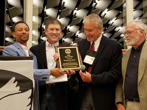 A group of men holding a plaque
AI-generated content may be incorrect.